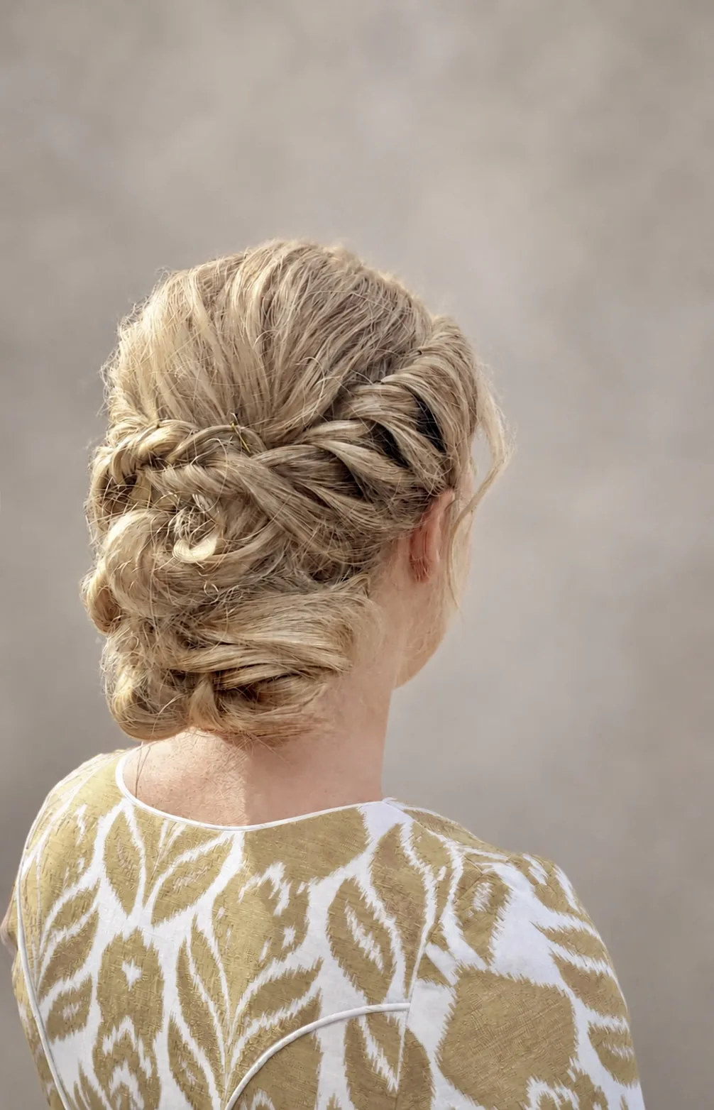 Human-hair wig styled into a braided updo, back view
