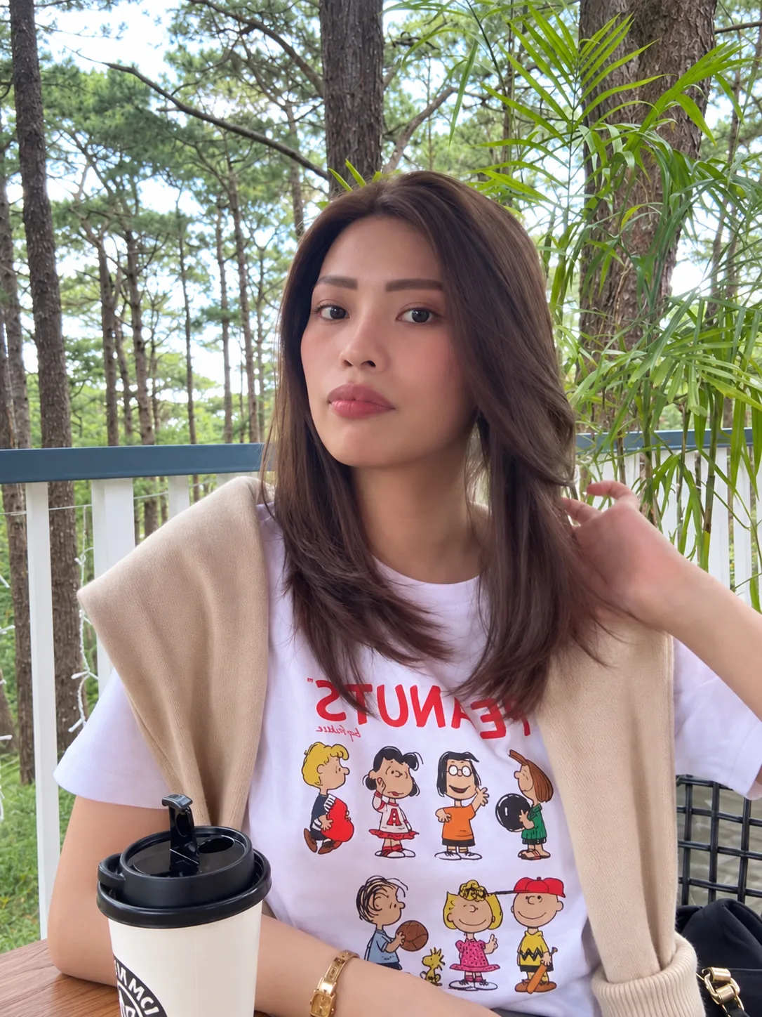 Brown layered lob human-hair wig worn outdoors with a coffee cup