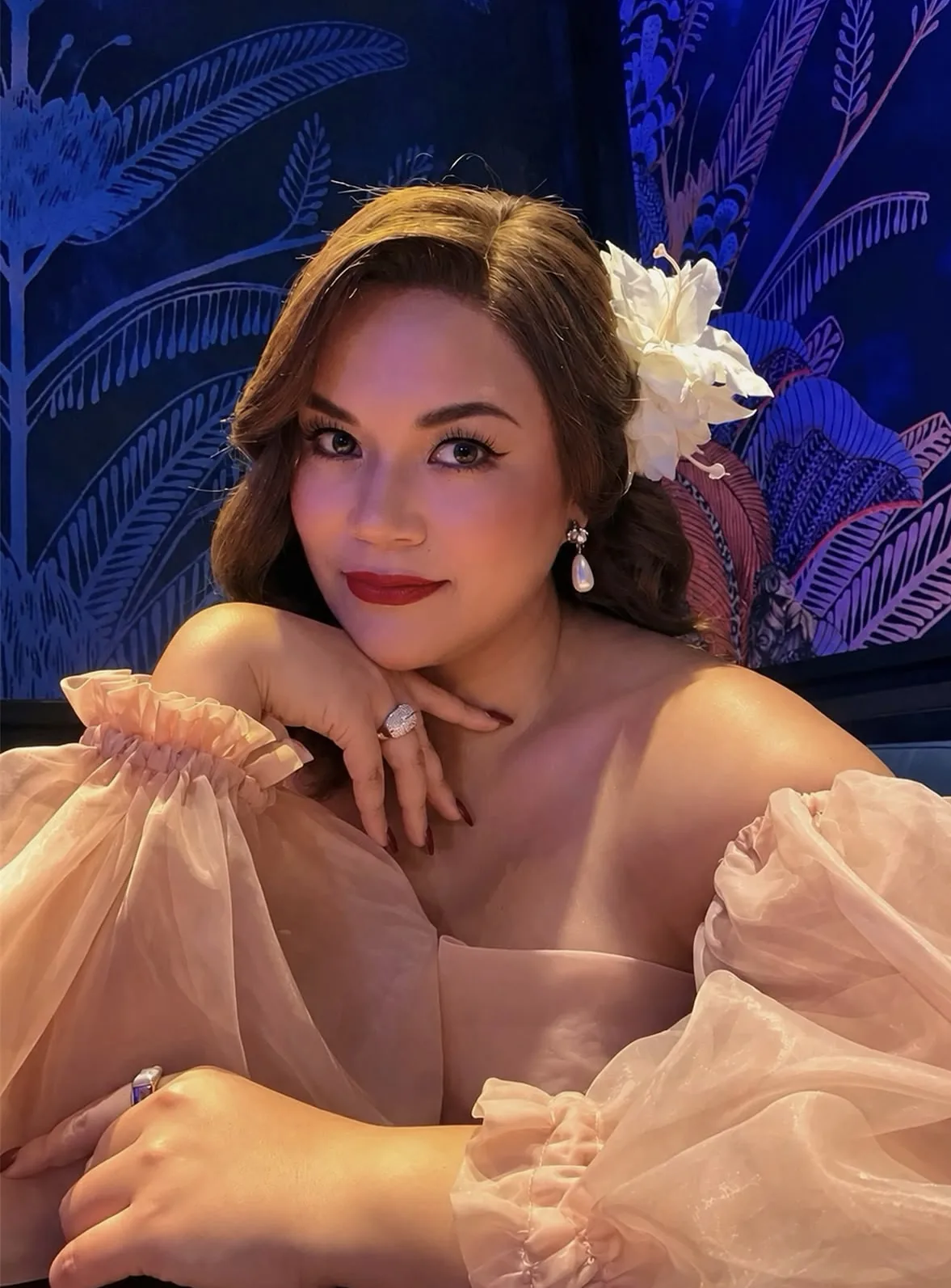 Seated evening portrait in a curled human-hair wig with a white flower
