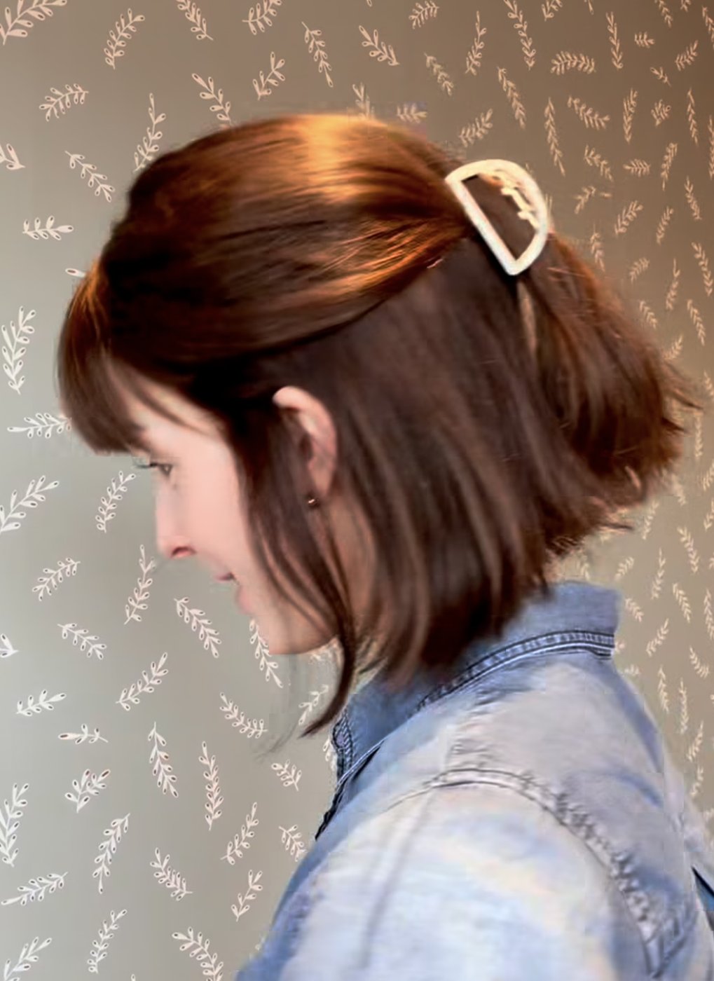 Bob wig with bangs pinned half-up with a claw clip, side view