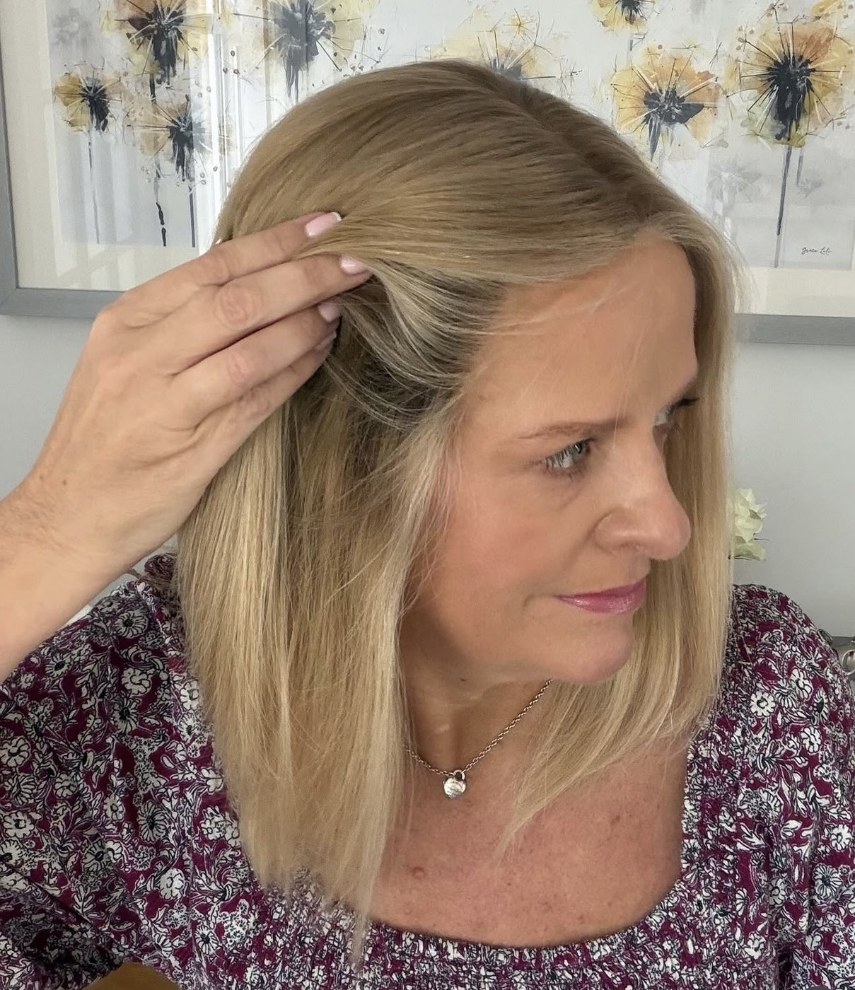 Client lifting her blonde wig hair to show the natural hairline and parting