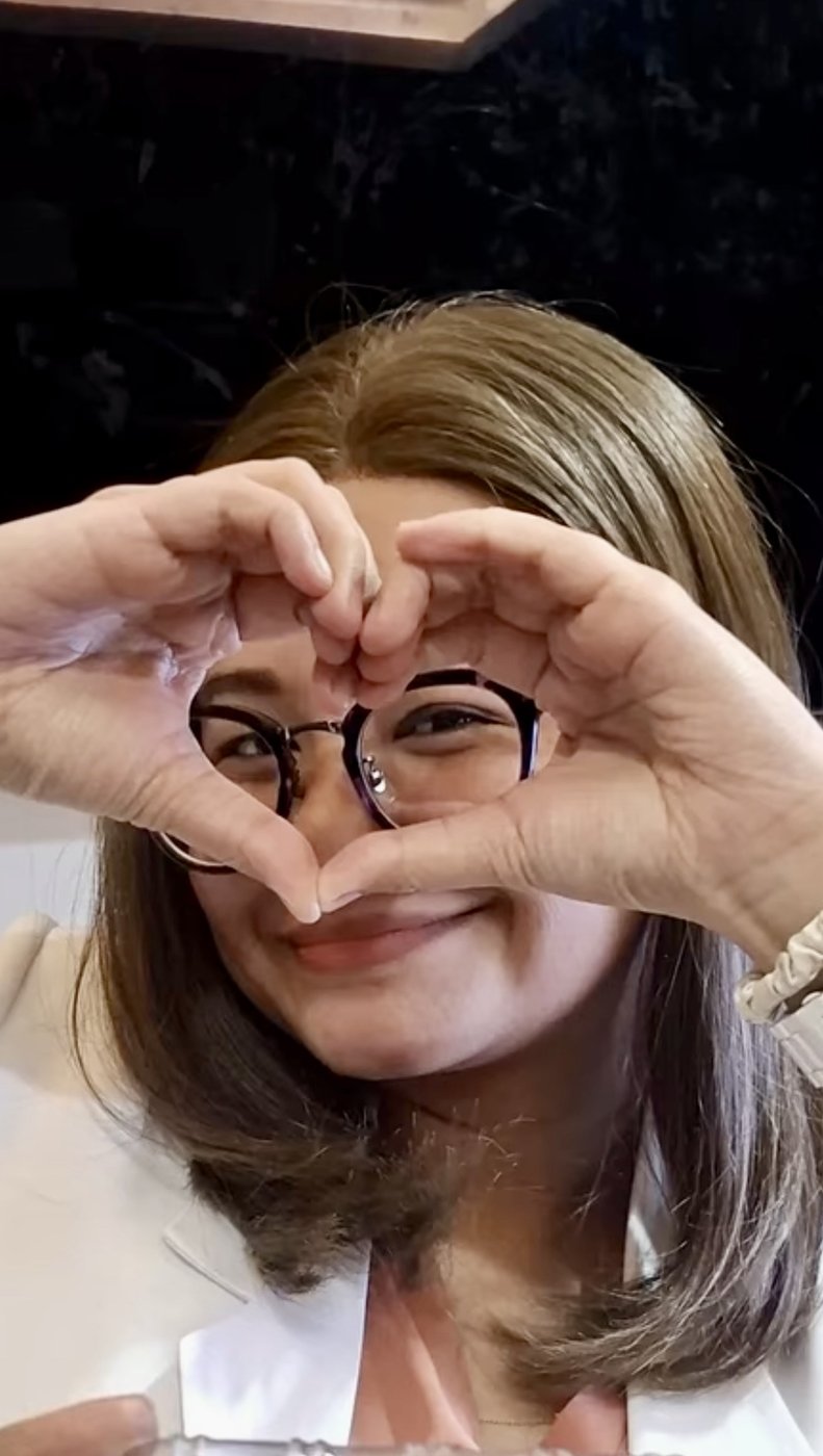 Happy client in a brown human hair wig making a heart