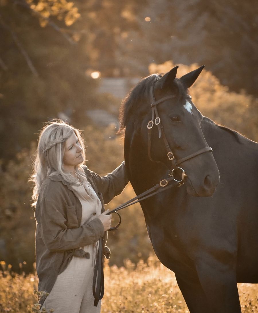 Client in a long blonde braided human hair wig at golden hour with her horse