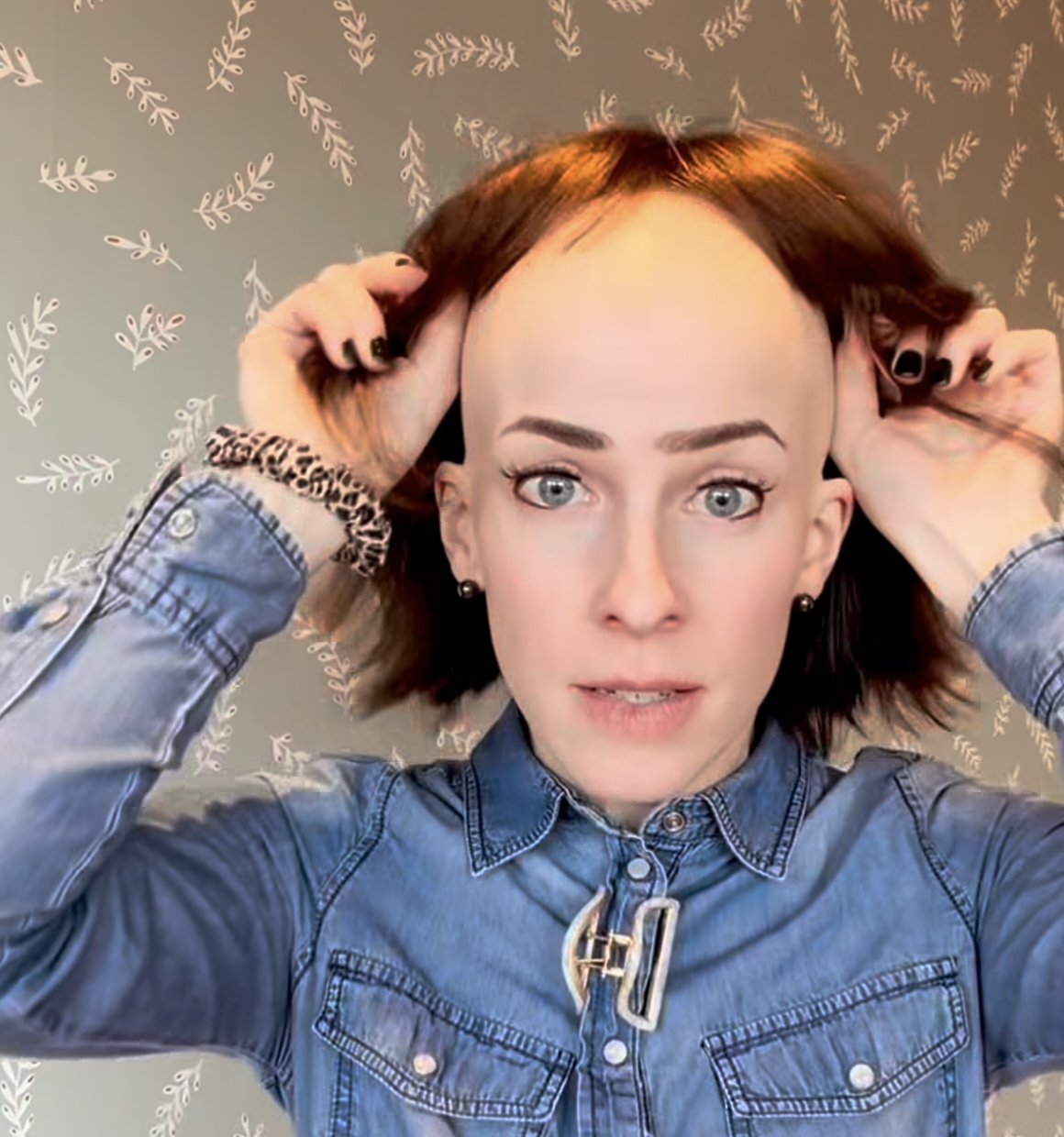Halfway into putting on a bob wig with bangs — honestly shown